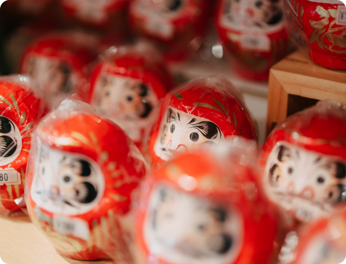 棚に商品として並ぶ赤いだるまたち